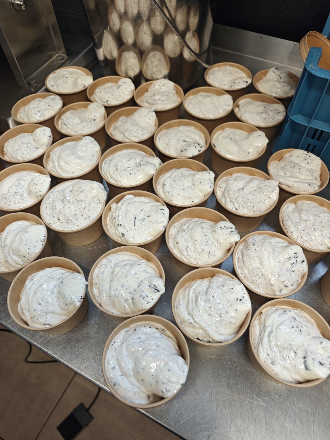 Frisch abgefüllte Becher mit Stracciatella-Eis in der Eismanufaktur Lindenhof
