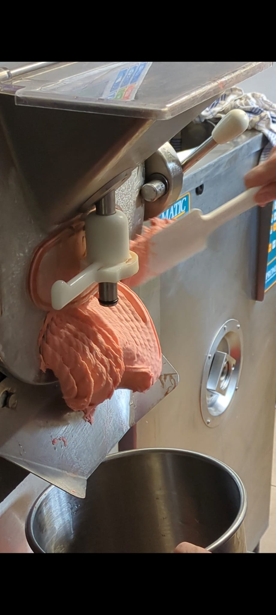 Frisches Fruchteis kommt aus der Eismaschine und wird von Hand entnommen